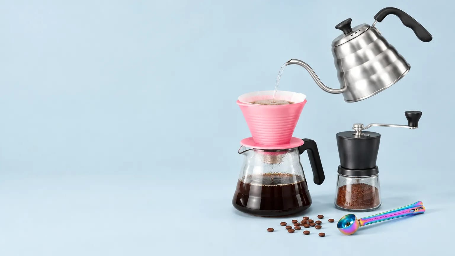 Brewlark pour over dripper, gooseneck kettle and manual grinder on a soft blue backdrop